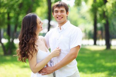 Mavi gökyüzü altında gülümseyen genç aşk Çift