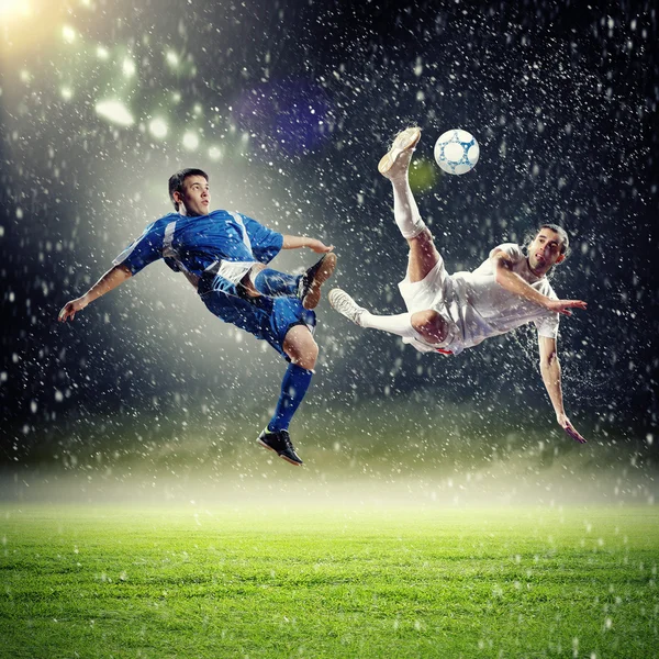 Dos jugadores de fútbol golpeando la pelota — Foto de Stock