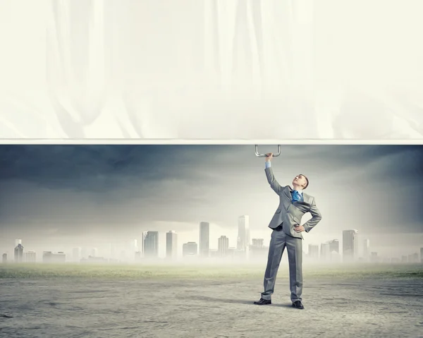 Young man pulling banner — Stock Photo, Image