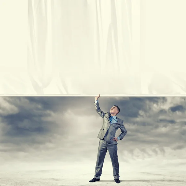 Young man pulling banner — Stock Photo, Image