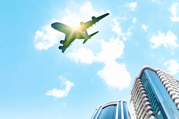 Airplane above city — Stock Photo, Image