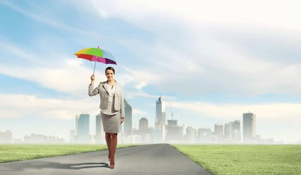 Young business woman holding an umbrella — Stock Photo, Image