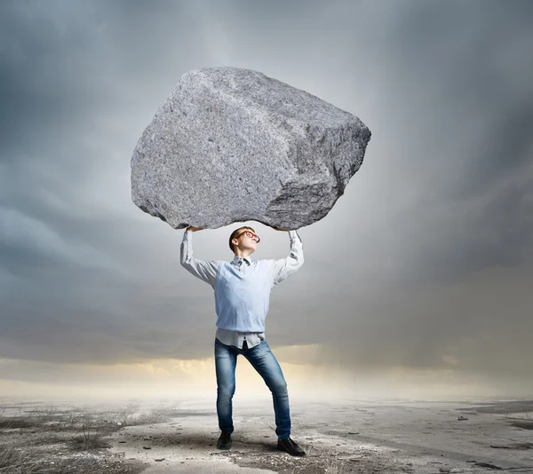 Guy lifting stone — Stock Photo, Image