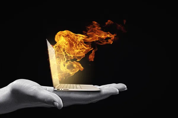 Menschliche Hand hält brennenden Laptop auf Handfläche — Stockbild Computerprobleme — Stockfoto