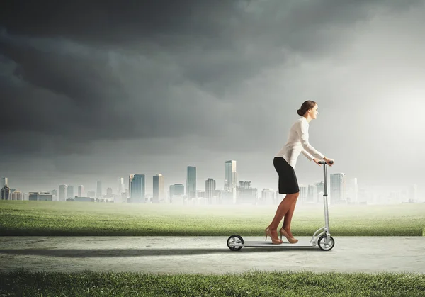 Businesswoman riding a scooter — Stock Photo, Image
