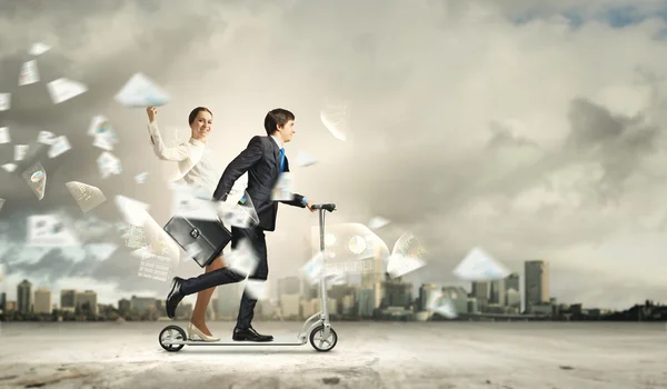 Empresários montando uma scooter — Fotografia de Stock