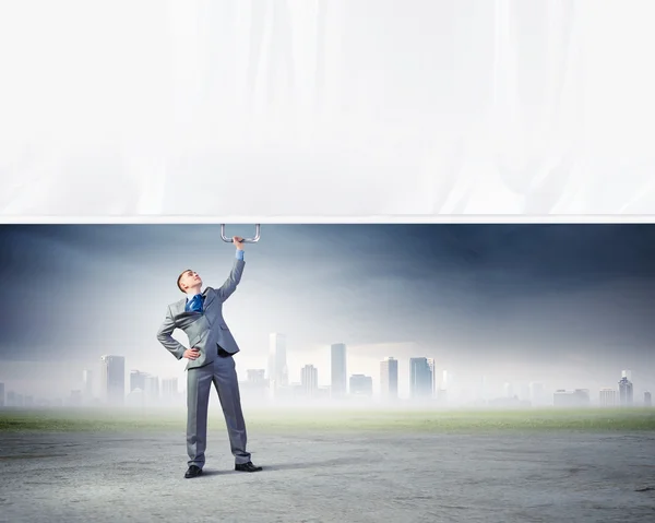 Young man pulling banner — Stock Photo, Image