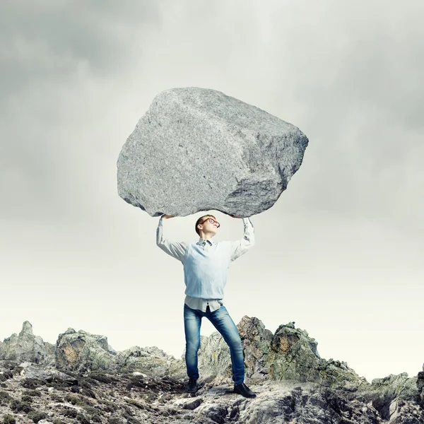 Guy lifting stone — Stock Photo, Image