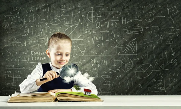 Schoolgirl examining opened book — Stock Photo, Image