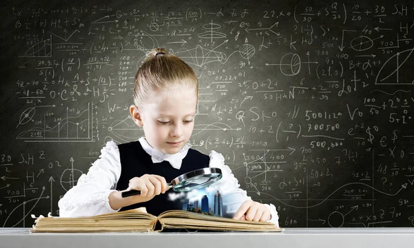 Schoolgirl examining opened book — Stock Photo, Image