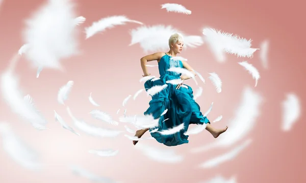 Женщина в синем платье прыгает — стоковое фото