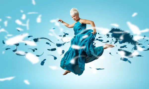 Femme en robe bleue sautant — Photo