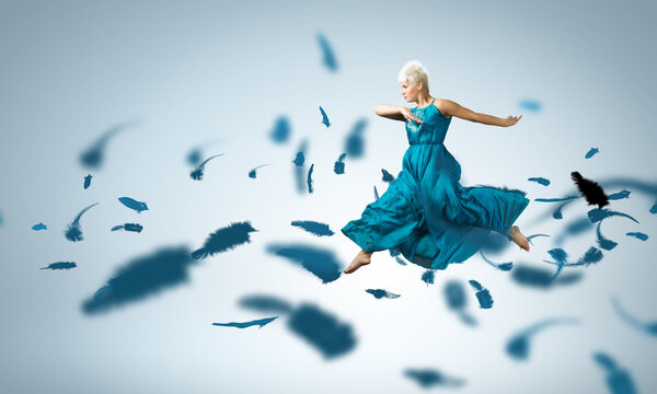 Женщина в синем платье прыгает
