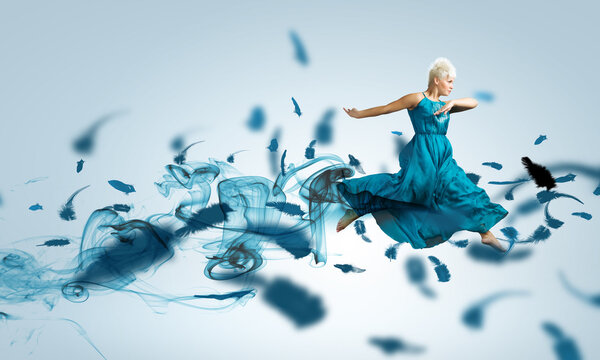 Женщина в синем платье прыгает
