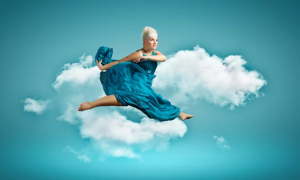 Femme en robe bleue sautant — Photo
