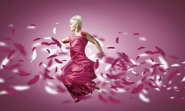 Donna in abito rosa saltando — Foto Stock