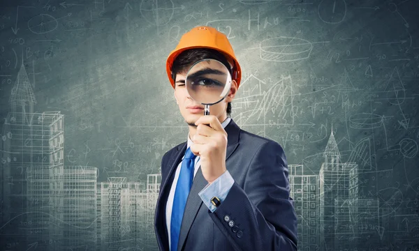 Architect looking in magnifying glass — Stock Photo, Image