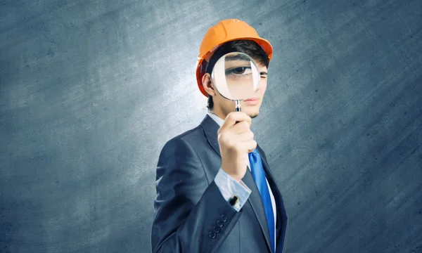 Architect looking in magnifying glass — Stock Photo, Image