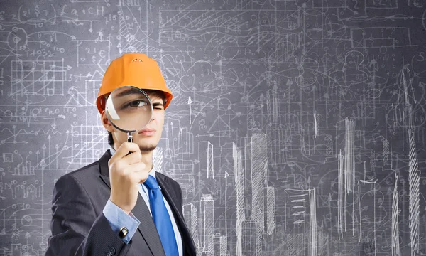 Architect looking in magnifying glass — Stock Photo, Image