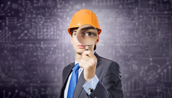 Architect looking in magnifying glass — Stock Photo, Image