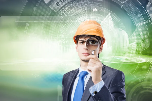 Engineer looking in magnifying glass — Stock Photo, Image