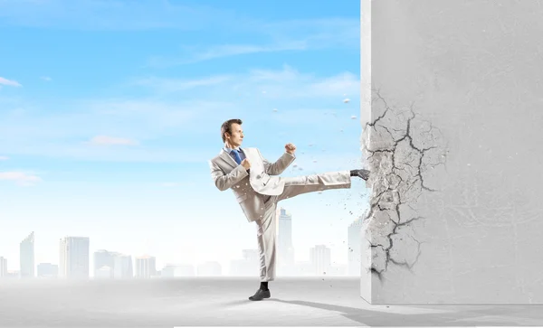 Businessman breaking stone wall — Stock Photo, Image