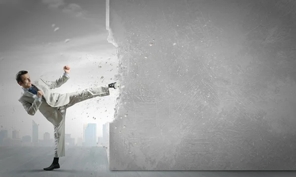 Businessman breaking stone wall — Stock Photo, Image