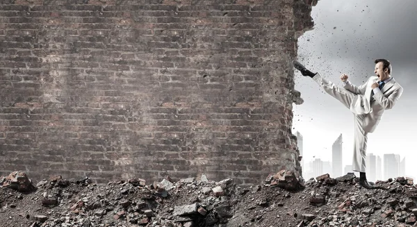 Zakenman breken stenen muur — Stockfoto