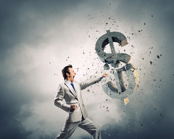 Businessman breaking stone dollar symbol — Stock Photo, Image