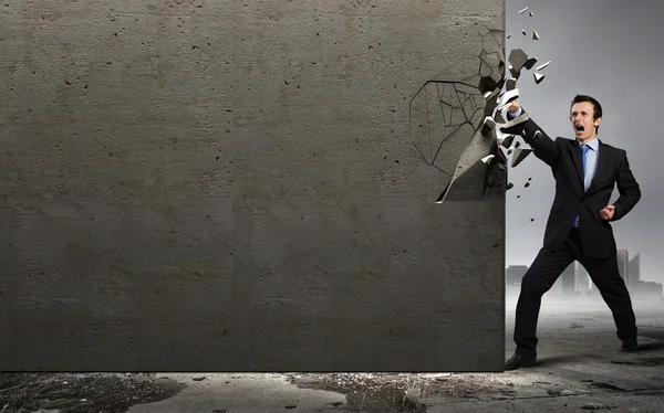 Businessman breaking stone wall — Stock Photo, Image