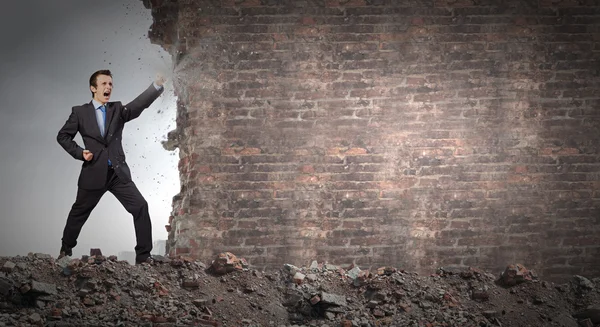 Zakenman breken stenen muur — Stockfoto