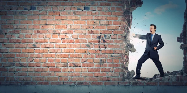 Zakenman breken stenen muur — Stockfoto