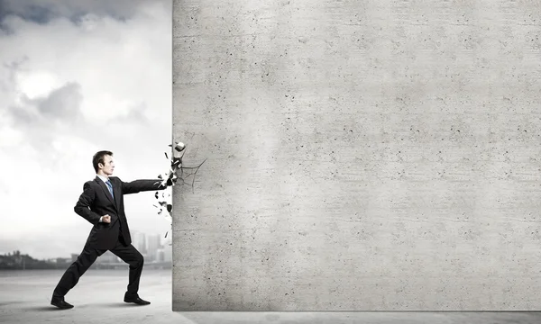 Businessman breaking stone wall — Stock Photo, Image