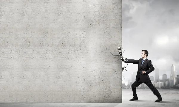 Businessman breaking stone wall — Stock Photo, Image