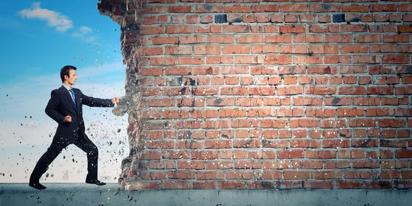 Zakenman breken stenen muur — Stockfoto