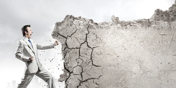 Uomo d'affari rompere muro di pietra — Foto Stock