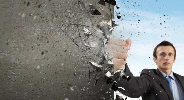 Businessman breaking stone wall — Stock Photo, Image