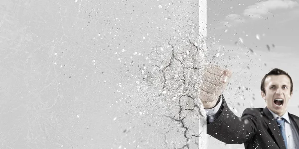 Businessman breaking stone wall — Stock Photo, Image