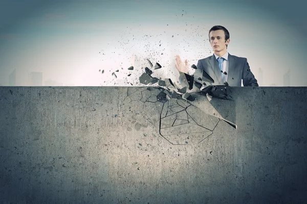 Businessman breaking stone wall — Stock Photo, Image