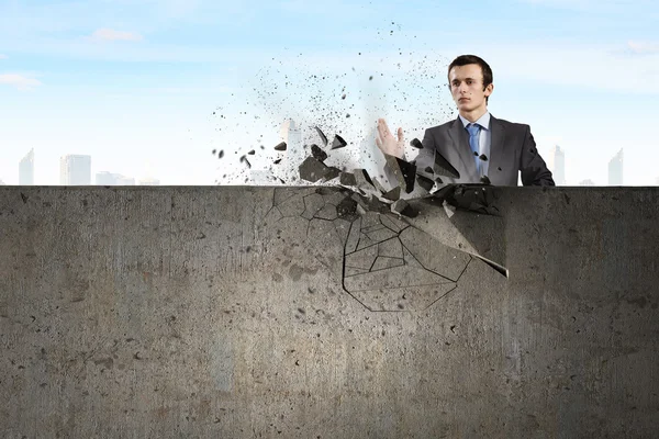 Businessman breaking stone wall — Stock Photo, Image