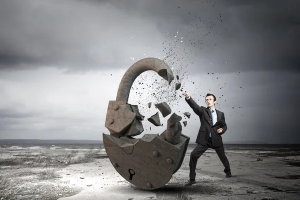 Businessman breaking stone lock — Stock Photo, Image
