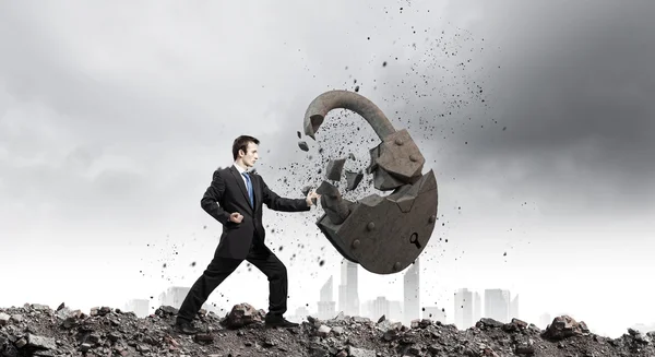 Empresario rompiendo cerradura de piedra — Foto de Stock