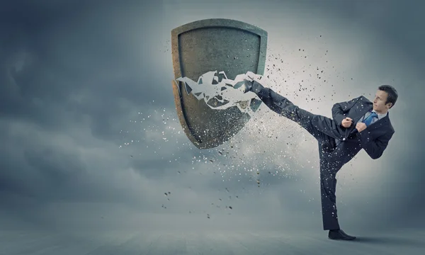 Businessman breaking stone shield — Stock Photo, Image
