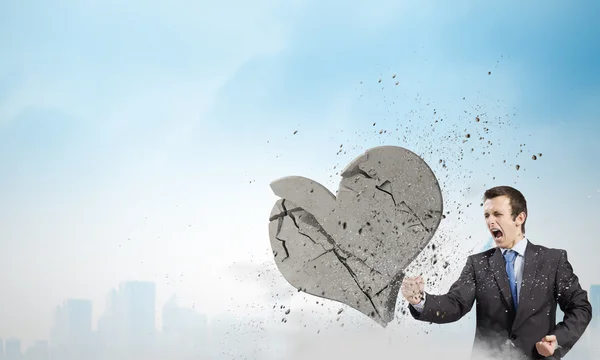 Businessman breaking stone heart — Stock Photo, Image