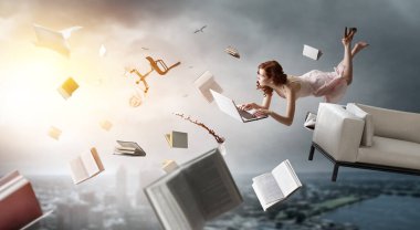 Genç bir kadın kitap okurken havaya yükselir. Karışık ortam