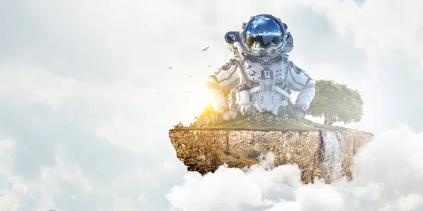 Astronaut na pozadí zatažené oblohy. Smíšená média — Stock fotografie