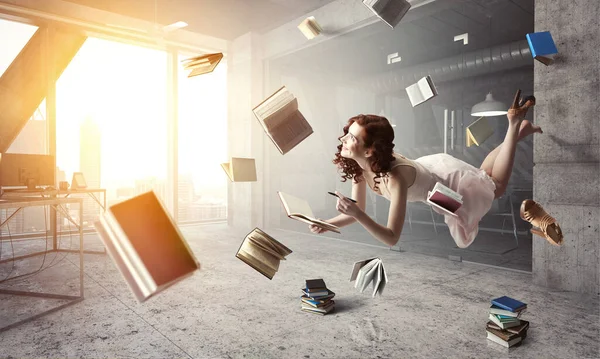 Młoda kobieta lewituje czytając książkę — Zdjęcie stockowe