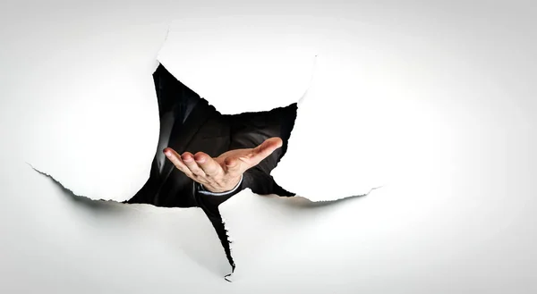 Image of hand in paper hole . Mixed media — Stock Photo, Image