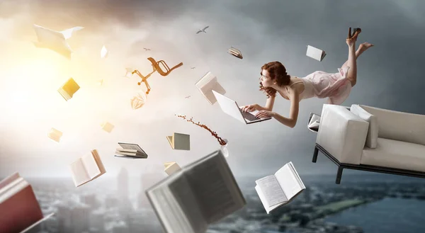 Young woman levitates while reading a book . Mixed media — Stock Photo, Image