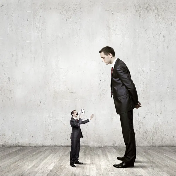 Businessman looking down at small businessman — Stock Photo, Image